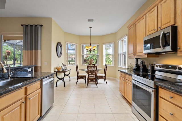 kitchen featuring stainless steel appliances, sink, a chandelier, hanging light fixtures, and light tile patterned flooring