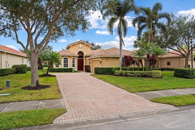 mediterranean / spanish home featuring a garage and a front lawn