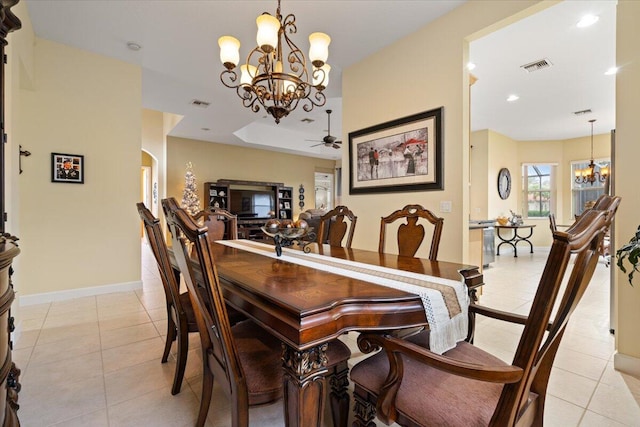 dining area featuring light tile patterned floors and ceiling fan with notable chandelier