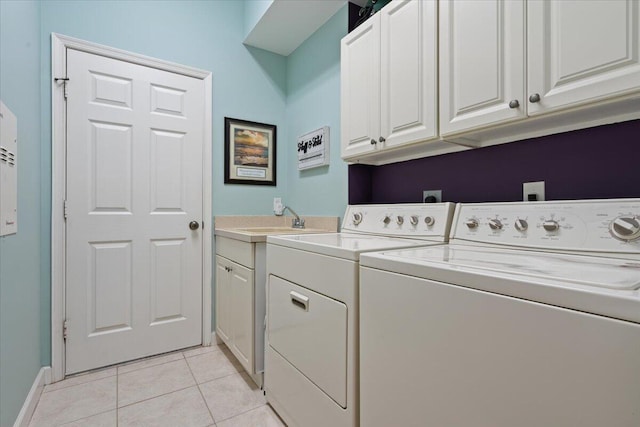 washroom with cabinets, light tile patterned floors, washing machine and dryer, and sink