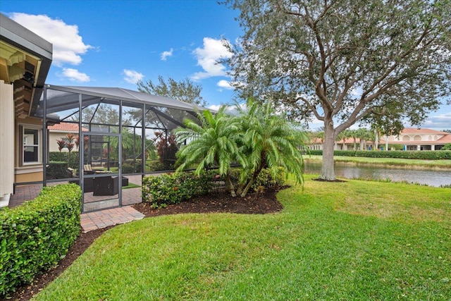 view of yard with a lanai and a water view