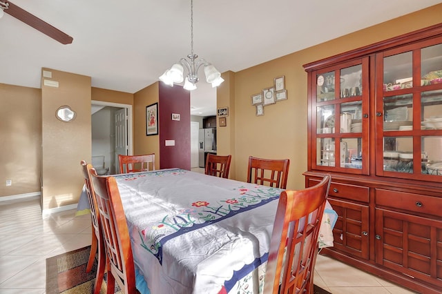 tiled dining space featuring an inviting chandelier