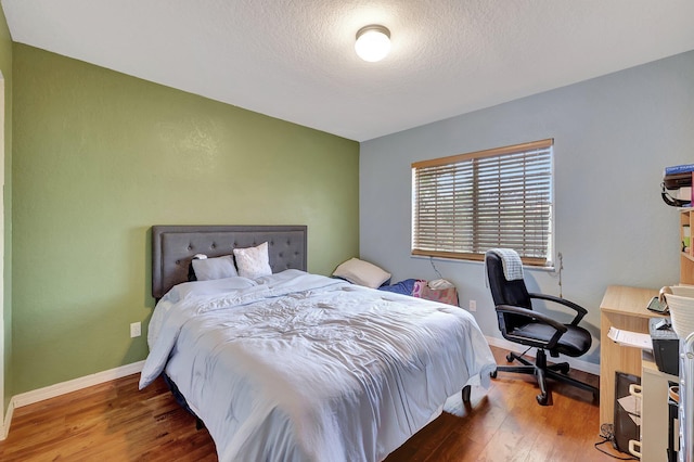 bedroom featuring a textured ceiling and hardwood / wood-style flooring