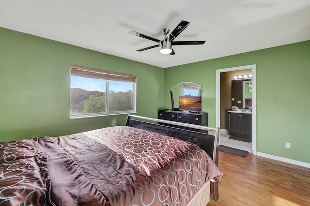 bedroom with ensuite bath, ceiling fan, and light hardwood / wood-style floors