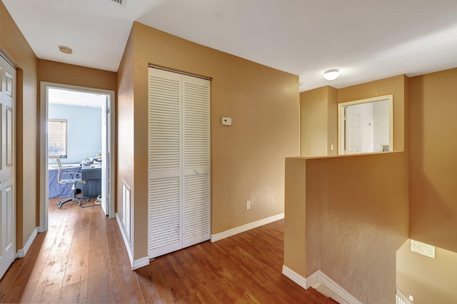 hallway with hardwood / wood-style floors