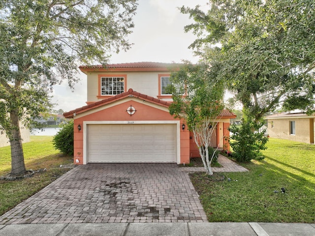 mediterranean / spanish-style house featuring a front yard and a garage