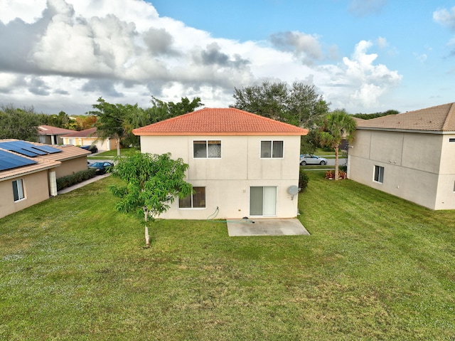 back of property featuring a patio and a lawn