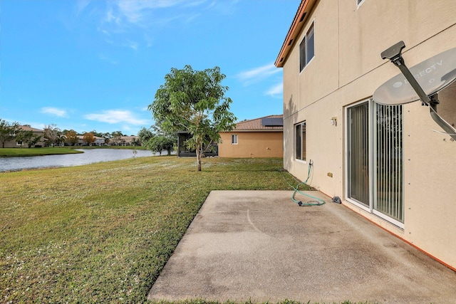 view of yard with a water view and a patio area