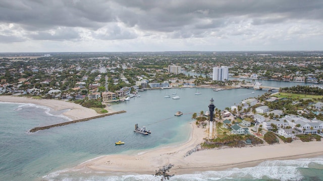 birds eye view of property with a water view and a beach view