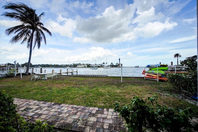 view of yard with a water view and a boat dock