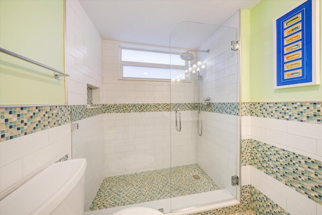 bathroom featuring a shower with door and tile walls