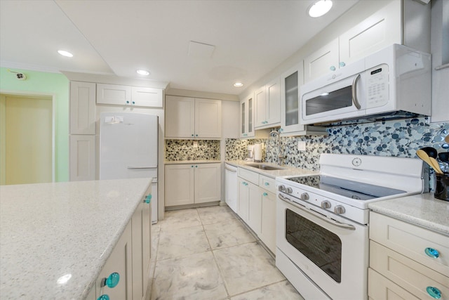 kitchen with white cabinetry, white appliances, sink, and light stone counters