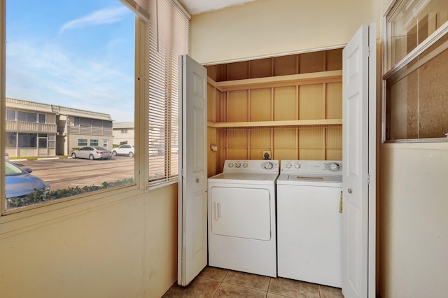 clothes washing area featuring washer and clothes dryer and light tile patterned floors