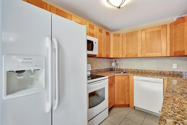 kitchen with tasteful backsplash, light stone counters, white appliances, sink, and light tile patterned floors