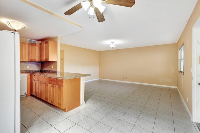 kitchen with kitchen peninsula, tasteful backsplash, ceiling fan, light tile patterned floors, and stone counters