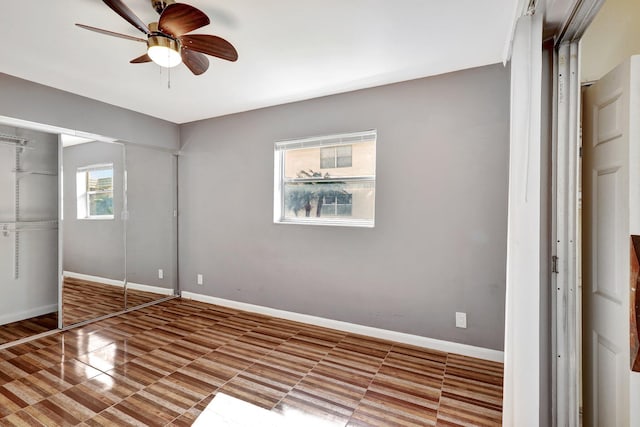 unfurnished bedroom featuring a closet, multiple windows, and ceiling fan