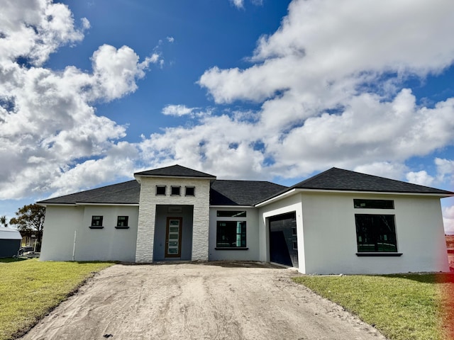 prairie-style home with a garage and a front lawn