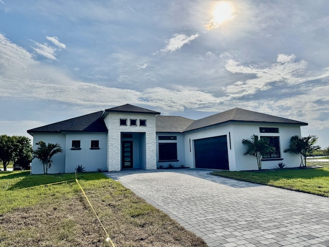 13200 SE US Highway 441, Okeechobee, FL 34974 - view of front of house with an attached garage, decorative driveway, a front yard, stucco siding, and stone siding