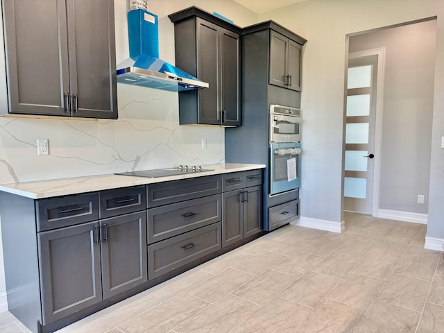 13200 SE US Highway 441, Okeechobee, FL 34974 - kitchen with wall chimney range hood, stainless steel double oven, black electric stovetop, baseboards, and backsplash