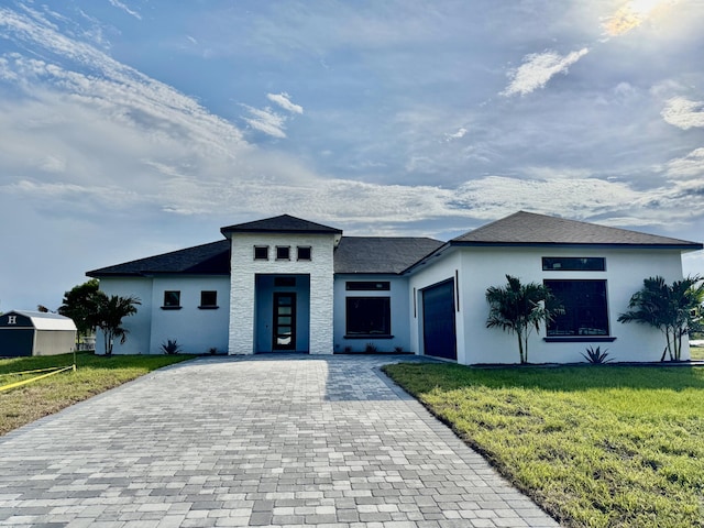 13200 SE US Highway 441, Okeechobee, FL 34974 - prairie-style home featuring decorative driveway, a garage, a front lawn, and stucco siding