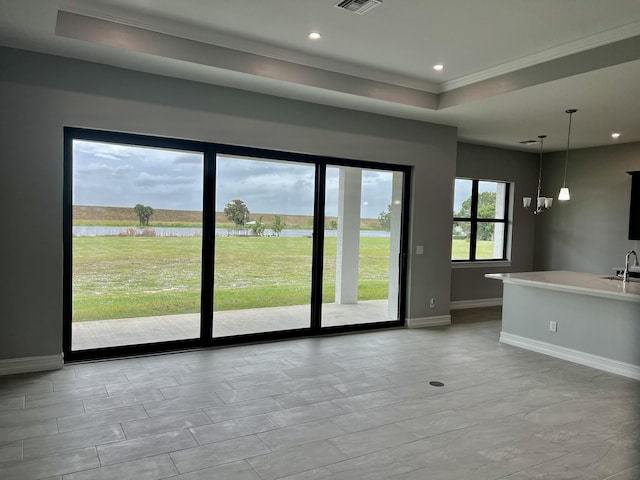 13200 SE US Highway 441, Okeechobee, FL 34974 - unfurnished room featuring a raised ceiling, baseboards, a sink, a water view, and crown molding
