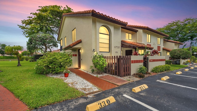 mediterranean / spanish-style house with a lawn