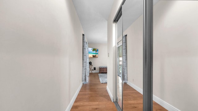 corridor with hardwood / wood-style floors