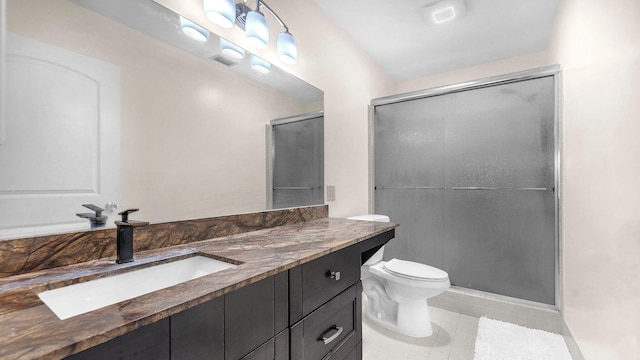 bathroom with tile patterned floors, vanity, toilet, and a shower with shower door