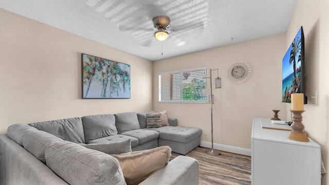 living room with ceiling fan, a textured ceiling, and hardwood / wood-style flooring