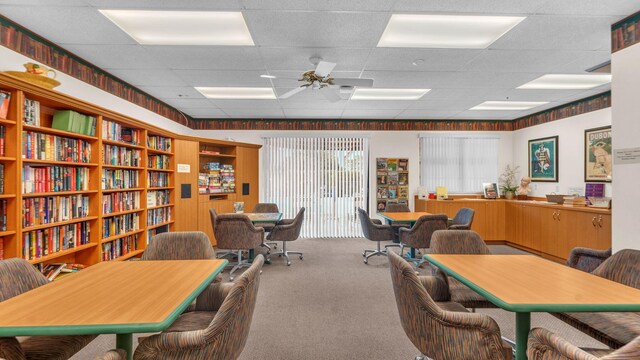 carpeted home office featuring a drop ceiling