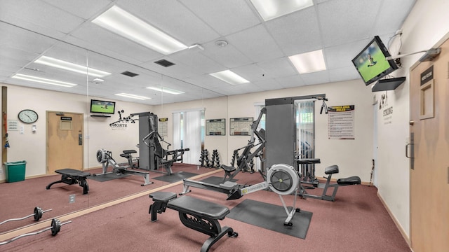 workout area featuring a paneled ceiling and carpet