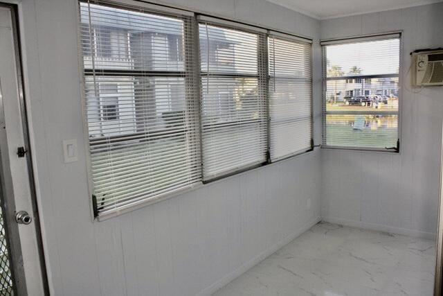 unfurnished sunroom with a wall unit AC