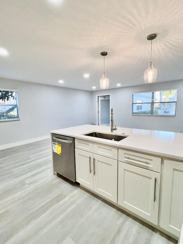 kitchen featuring light hardwood / wood-style floors, dishwasher, hanging light fixtures, and sink