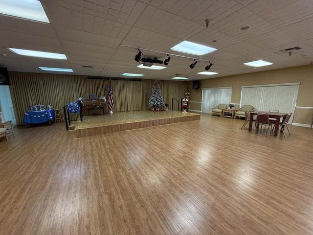 exercise room with hardwood / wood-style floors and a drop ceiling