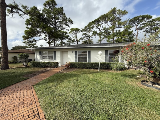 ranch-style home featuring a front lawn