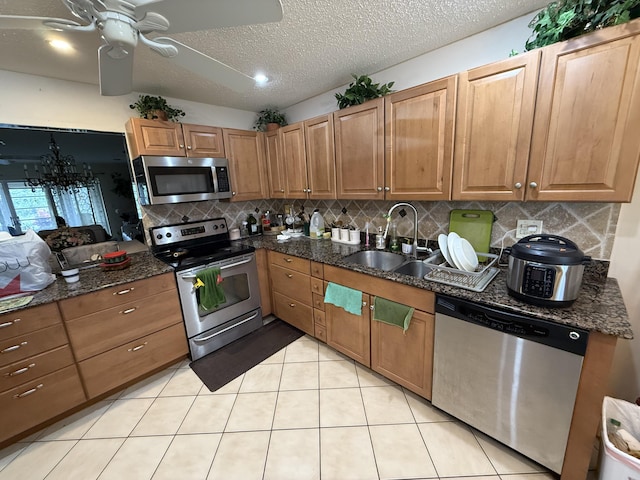 kitchen with ceiling fan, sink, a textured ceiling, light tile patterned floors, and appliances with stainless steel finishes