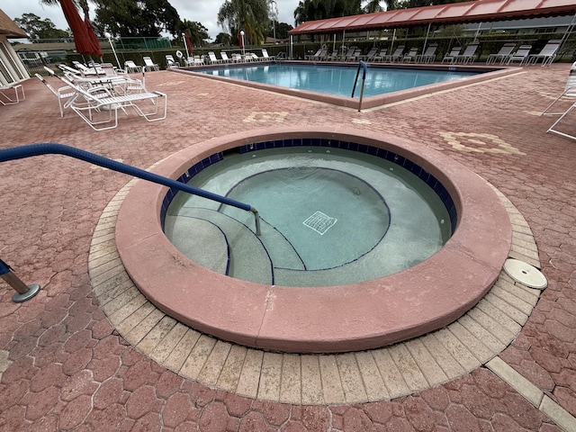 view of pool with a community hot tub and a patio