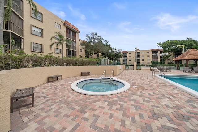 view of pool with a gazebo, a patio, and a hot tub