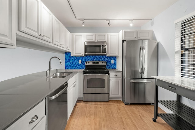 kitchen with sink, white cabinets, stainless steel appliances, and light hardwood / wood-style floors