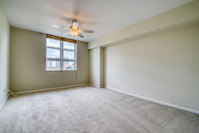 empty room with light carpet, a textured ceiling, and ceiling fan