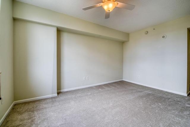 carpeted empty room with ceiling fan and a textured ceiling