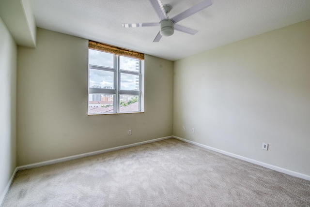 unfurnished room with ceiling fan and light carpet