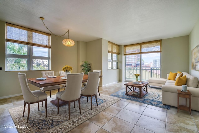 tiled dining space with a wealth of natural light and a textured ceiling