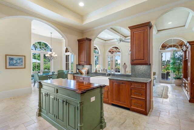 kitchen with a healthy amount of sunlight, ornamental molding, and tasteful backsplash