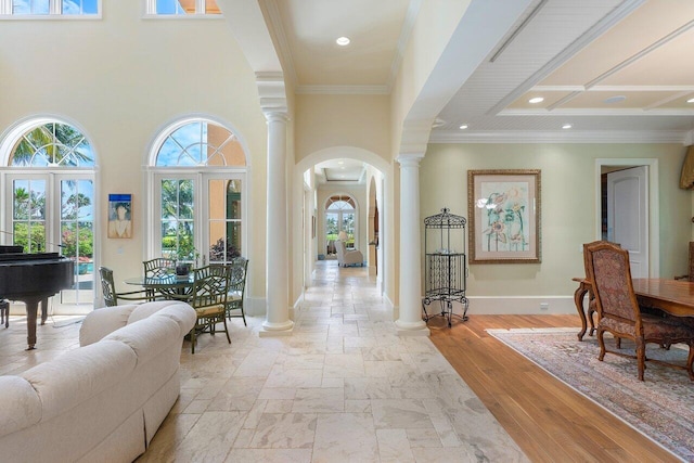 entrance foyer with french doors, ornamental molding, coffered ceiling, and light wood-type flooring