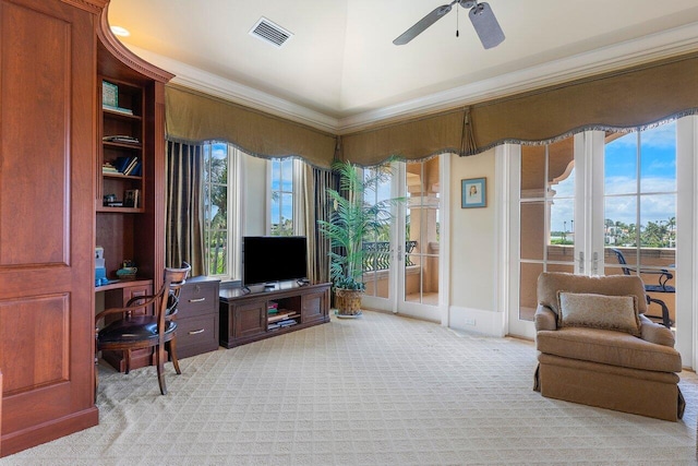 interior space with french doors, light colored carpet, ceiling fan, and ornamental molding