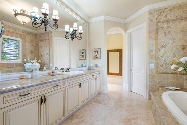 bathroom with tiled bath, vanity, a notable chandelier, and ornamental molding