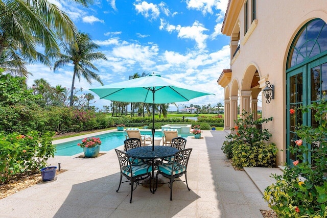 view of patio featuring a pool with hot tub