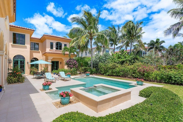 view of pool with an in ground hot tub and a patio