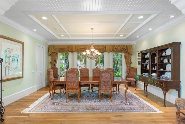 dining area with coffered ceiling, light wood-type flooring, crown molding, and an inviting chandelier